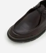 Zapato de vestir negro con cordones, fabricado en cuero sintético, con puntera redondeada y suela de goma.