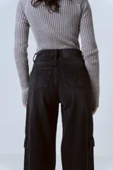 Pantalón wide leg color negro con bolsillos cargo laterales y tiro alto.