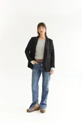 Blazer azul marino de tela agamusada, corte clásico, con solapas y bolsillos frontales.