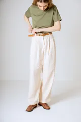 Pantalón negro de corte ancho y tiro alto, con pinzas en la cintura y bolsillos laterales.