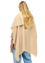 Ruana de tejido soft color beige, con cuello en V y un lazo o pasador frontal para ajustar. El ruedo tiene terminación desflecada.