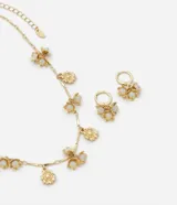 Conjunto de collar y aros dorados con colgantes de flores y centro de cristal lechoso.