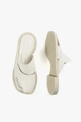 Sandalia de cuero color blanco, con diseño de tiras cruzadas y talón descubierto.
