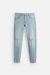 Pantalón de jean celeste de corte skinny con roturas en las rodillas.