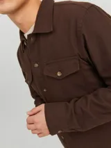 Sobrecamisa marrón de manga larga con cuello de camisa, cierre con botones y dos bolsillos con solapa en el pecho.