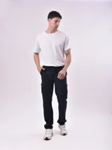 Pantalón cargo negro con cintura elástica ajustable con cordón, bolsillos laterales y traseros con solapa.