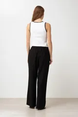 Pantalón de lino color marrón claro, de corte recto y tiro alto, con cintura elástica ajustable con cordón.