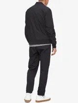Campera bomber negra Calvin Klein de poliéster y algodón, con cuello redondo, cierre frontal, bolsillos laterales con cierre, logo en el pecho y ribete de punto acanalado.