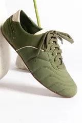 Zapatillas acordonadas color beige con detalles en blanco.