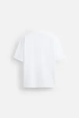 Camiseta blanca de algodón compacto, corte relaxed fit, cuello redondo y mangas cortas.