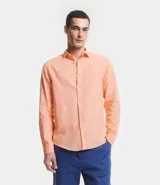 Camisa celeste de lino con cuello camisero, abotonadura frontal y mangas largas.