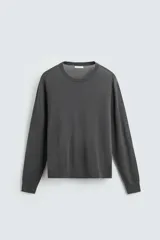 Sweater gris oscuro de lana mercerizada, corte recto, cuello redondo y mangas largas con terminaciones en rib.