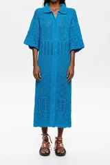 Vestido largo de crochet color celeste con cuello camisero, manga corta y cierre frontal con botones.