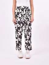 Pantalón babucha de tela estampada en blanco y negro con diseño abstracto floral.