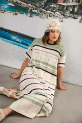 Vestido largo de tejido calado con rayas horizontales en color crudo, azul marino y rojo. Tiene tajo lateral y logo bordado en la manga.