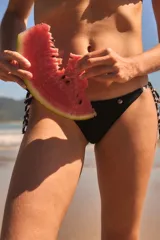 Conjunto de bikini azul de terciopelo, compuesto por un corpiño triangular con tirantes finos y una bombacha con lazos laterales.