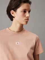 Remera color salmón de algodón con cuello redondo, mangas cortas y logo de Calvin Klein en el pecho.