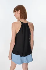 Musculosa color beige de lino, con cuello halter con volados y volados en el ruedo.