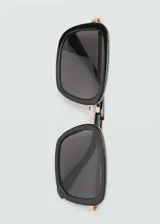 Lentes de sol cuadrados con montura de pasta negra, puente metálico y lentes grises.