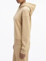 Buzo color beige de corte holgado, con capucha y logo de Calvin Klein bordado en el pecho.