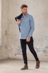 Camisa celeste de corte clásico, manga larga y cuello abotonado.