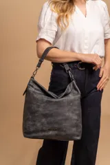 Cartera bandolera color marrón claro, de símil cuero, con dos divisiones internas, asa corta fija y correa larga regulable.