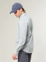 Camisa de vestir a rayas verticales azules y blancas, corte slim fit, con cuello abotonado y logo bordado en el pecho.
