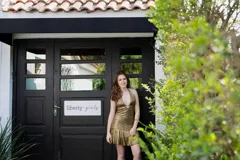 Vestido corto con lentejuelas color verde esmeralda, escote en V profundo y espalda descubierta.