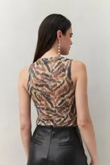 Top sin mangas con estampado animal print en tonos tierra, de silueta ajustada y cuello cerrado.