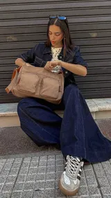 Bandolera de tafeta impermeable, liviana, con dos compartimientos principales, dos bolsillos con cierre y correa regulable con hebilla.