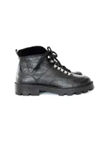 Borcego negro de cuero sintético con textura croco, cordones negros y suela track.