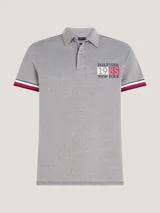 Chomba gris de corte slim confeccionada en algodón orgánico elástico, con cuello clásico, cartera de dos botones, logo de Tommy Hilfiger bordado en el pecho y ribetes distintivos en los puños.