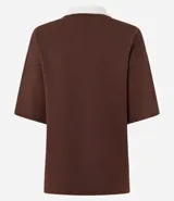 Remera marrón de punto con cuello polo blanco, mangas cortas y estampado jacquard con la frase "Malibu Beach" y una flor de hibisco celeste.