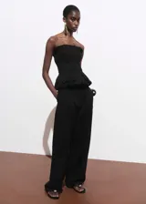 Pantalón negro de tiro medio y corte recto, confeccionado en mezcla de algodón y poliamida. Presenta trabillas, dos bolsillos laterales y cierre oculto de botón, gancho y cremallera.