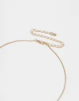 Collar corto dorado con cadena fina y dijes de frutas con strass. Cierre de mosquetón.