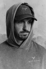 Buzo deportivo sin mangas en color gris con efecto lavado. Modelo de corte holgado con capucha forrada cruzada, bolsillo canguro y diseño reflectante en pecho y espalda. Remate acanalado ancho en el bajo. Interior cepillado suave.