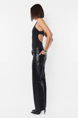 Pantalón recto de cuerina color negro, de tiro medio-bajo, con bolsillos delanteros y traseros, presillas en la cintura y cierre metálico.