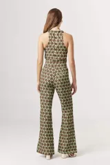 Top corto tipo crop top, sin mangas y con cuello halter. Presenta un estampado grande de flores en tonos verde claro, verde azulado y beige/crema.