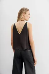 Top sin mangas color rosa pálido con escote en V profundo y vivos en lurex dorado en el contorno del escote y los hombros.