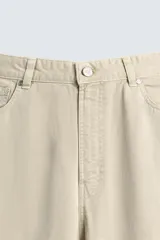 Pantalón de jean blanco, corte holgado y amplio en toda la pierna, tiro medio, tejido ligero, cinco bolsillos, efecto lavado y cierre frontal con cremallera y botón.