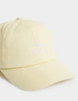 Gorra amarilla de gabardina con bordado de cerezas blancas en el frente y hebilla metálica ajustable en la parte posterior.