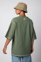 Remera negra oversize con mangas cortas y costuras a la vista en color blanco.