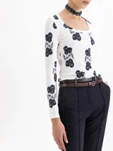 Remera de morley de punto color blanco con estampado de cerezas en azul oscuro, de calce al cuerpo, escote redondo y mangas largas.