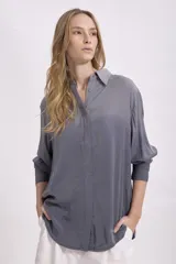 Camisa gris de corte holgado, con cuello clásico y mangas 3/4.