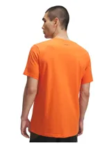 Remera deportiva Under Armour color naranja con logo estampado en el frente en tonos amarillo y rojo.
