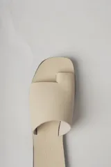 Sandalias planas de cuero color negro, con tira ancha sobre el empeine y diseño minimalista.