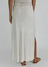 Conjunto color gris topo, compuesto por musculosa con cuello redondo y falda larga con cintura elastizada y cordón ajustable.