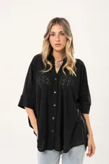 Camisa negra con calados, escote en V, abotonada y manga 3/4.