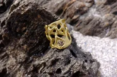 Anillo dorado con diseño abstracto con aberturas.