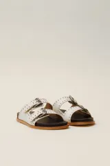 Sandalias marrones de cuero vacuno con doble tira y hebillas metálicas ajustables.